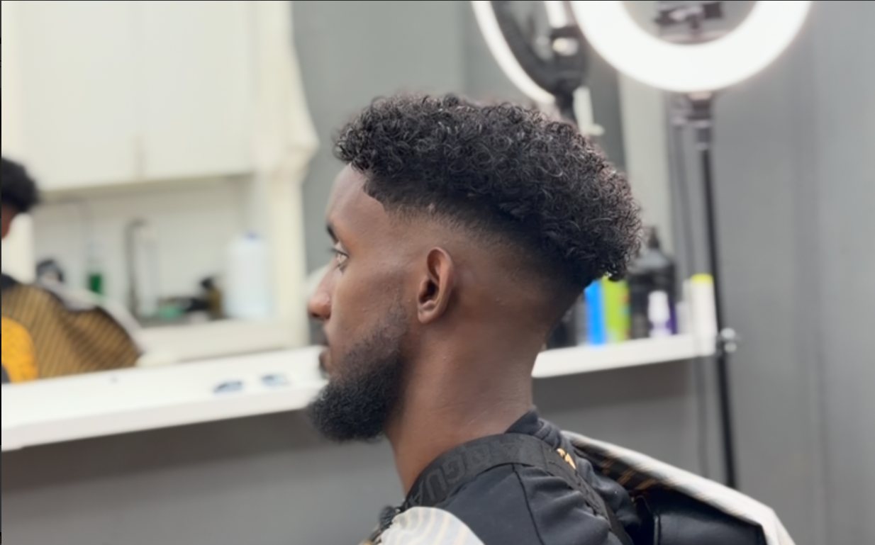 Lockigt hår på toppen med låg skinfade, klippt på Mo Cutz