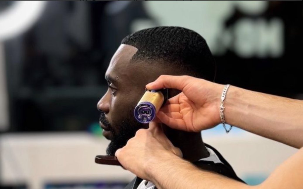 Barber trimmar konturen vid örat med trimmer